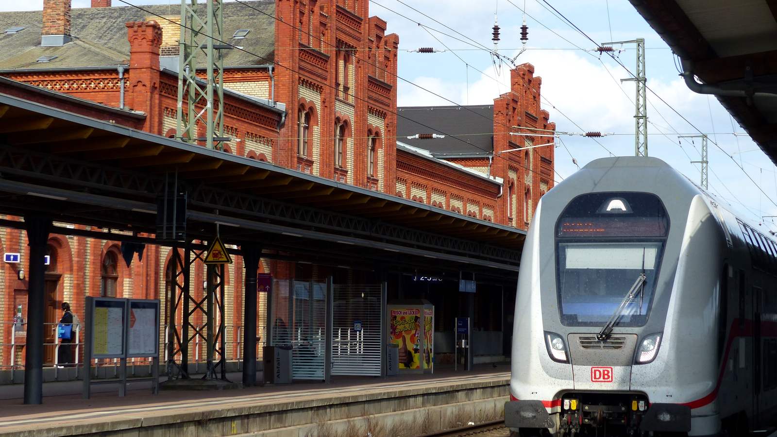 Bahnhof Stendal mit rotem Backstein-Empfangsgebäude, Bahnsteigdach und einem Intercity-Doppelstockzug der DB am Bahnsteig